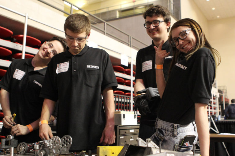 Team posing as they work on their robot